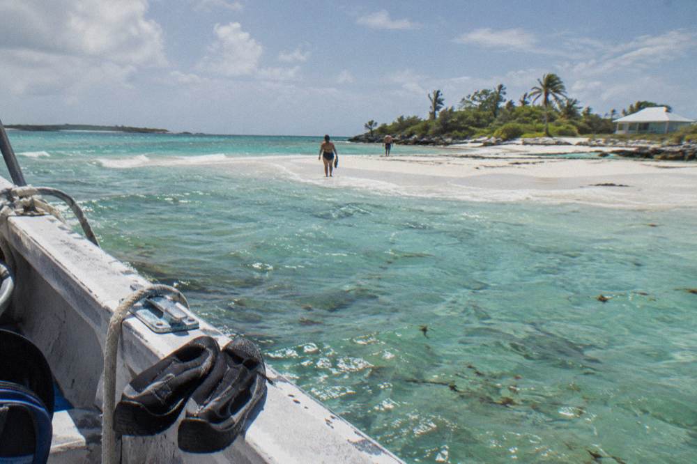 A white sandbar exposed in calm turquoise water under a clear sky