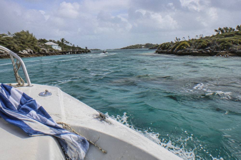 A powerboat cruising across clear turquoise water between small cays