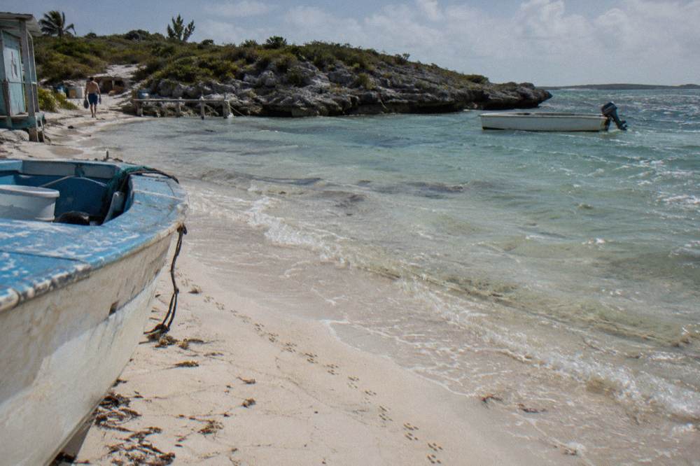 A shallow sandbar striped with clear water under a bright sky