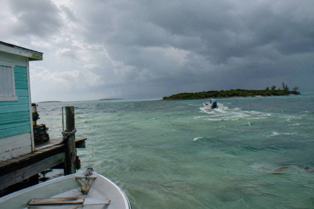 Dark storm clouds building over calm Exuma shallows