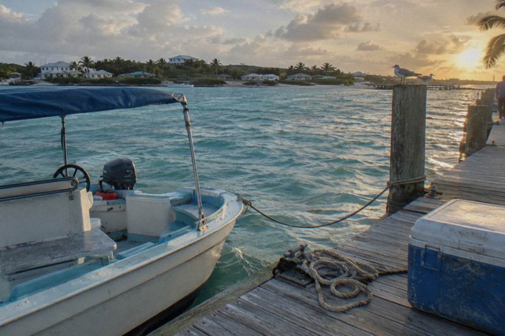 A tour boat at a wooden dock in a quiet turquoise harbor