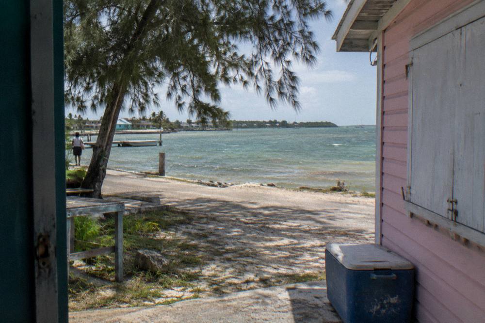 A quiet beach on Great Exuma with pale sand and calm green water