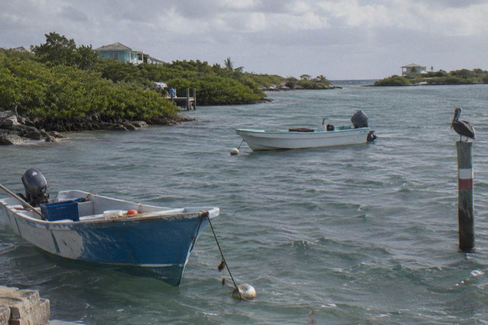 Anchored boats in a protected turquoise anchorage between green cays