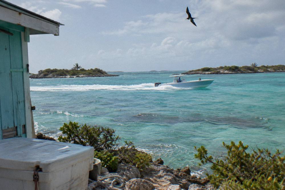 A speedboat crossing calm turquoise water between small cays