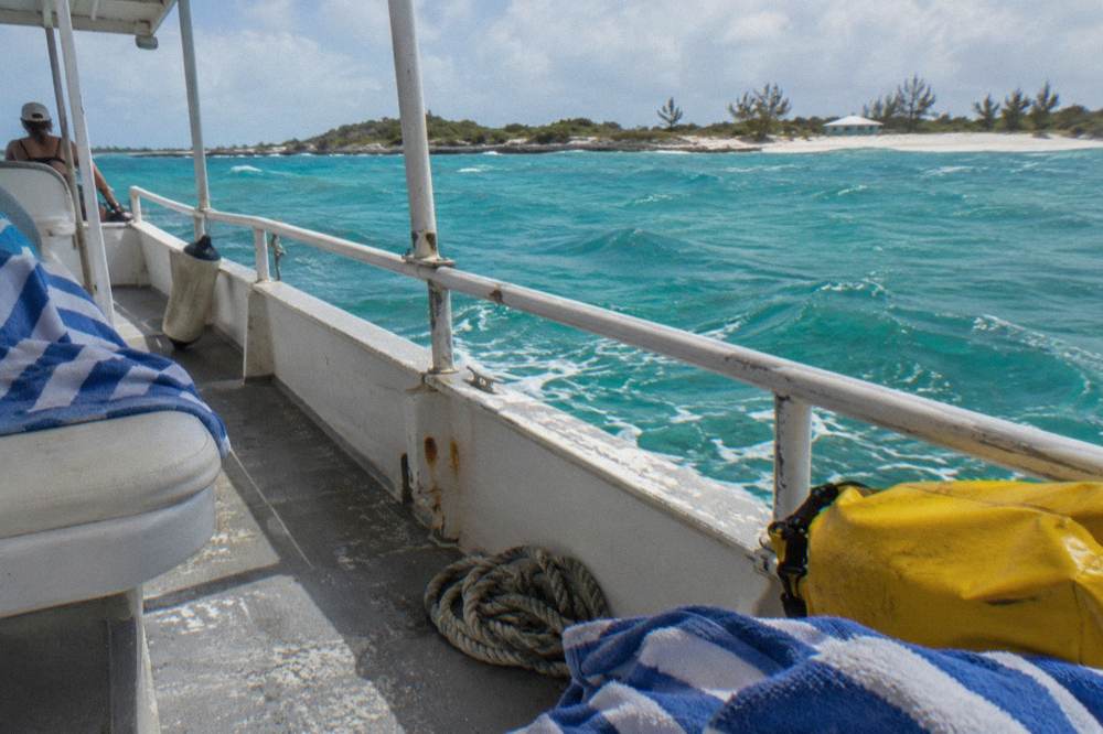 A shaded boat deck with towels and a dry bag ready for a day trip