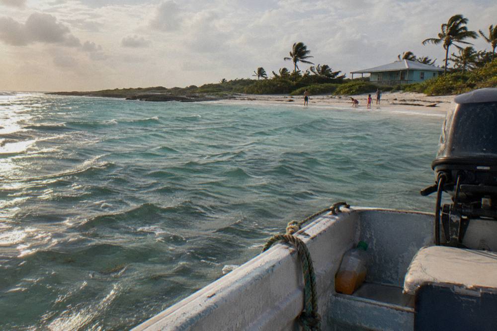 A family boat moored at a small cay with clear shallow water