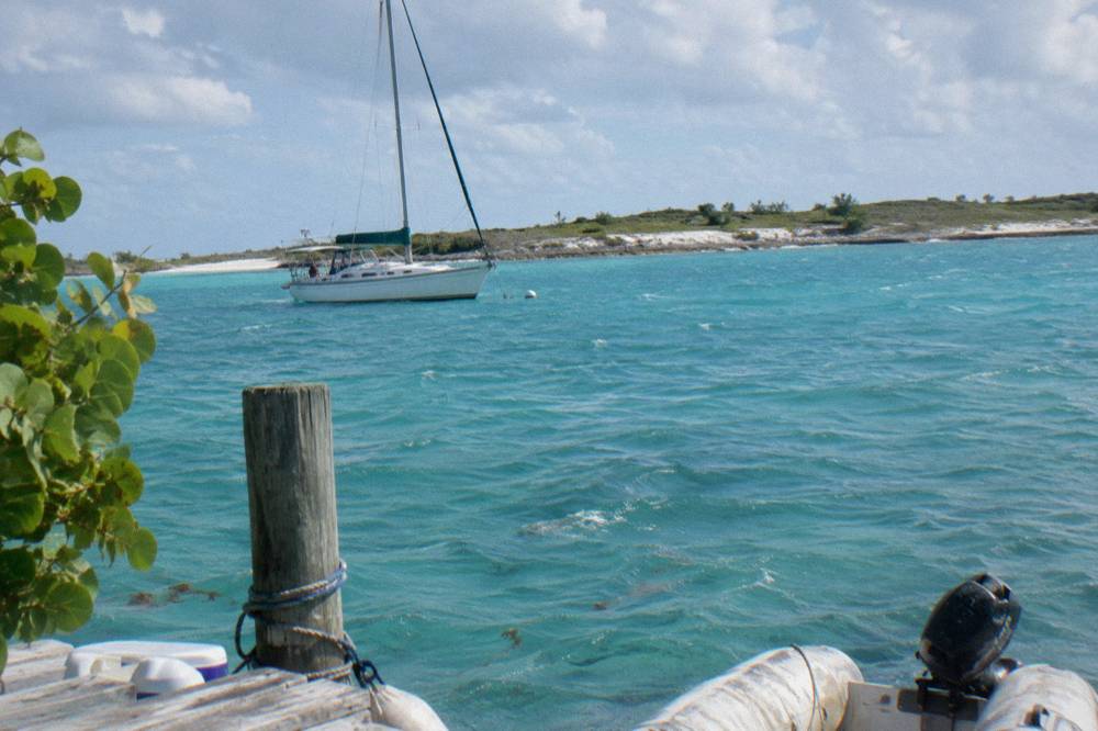 Turquoise anchorage with moored sailboats and a low sand spit inside the Exuma Cays Land and Sea Park
