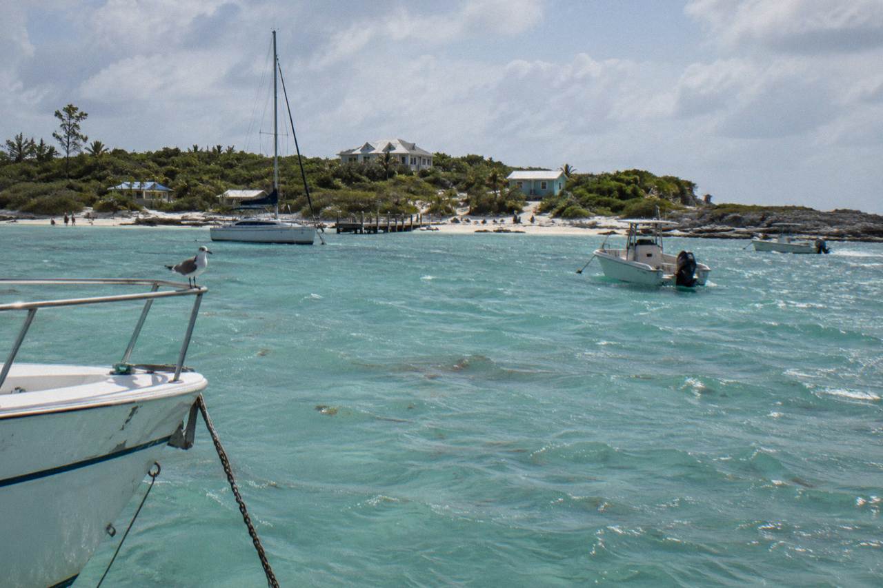 Turquoise shallow water around a small Bahamian cay with anchored boats