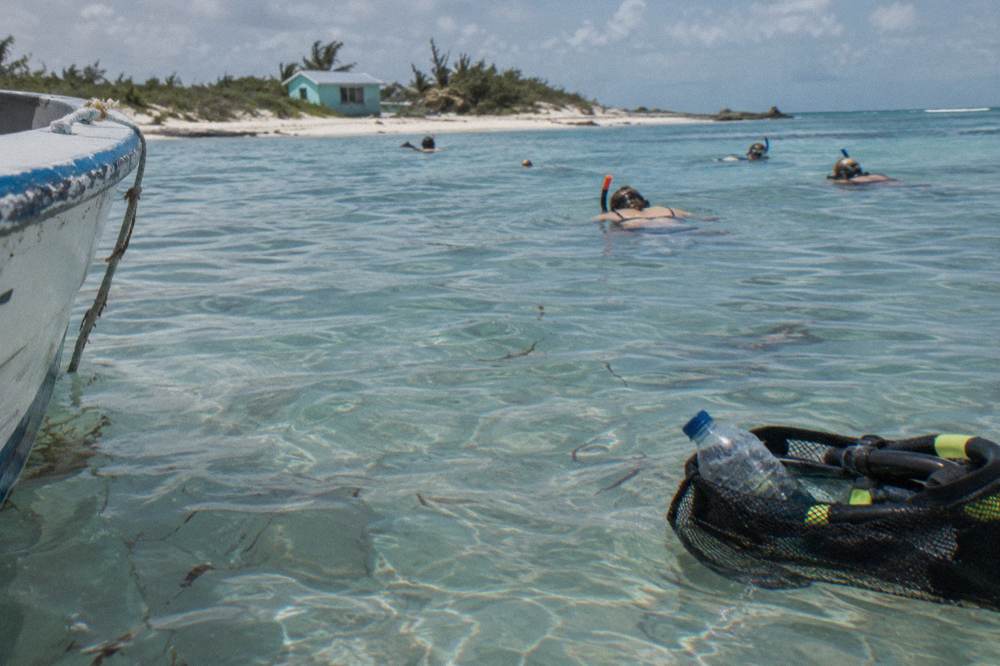 Snorkelers floating in the clear water at a small Exuma sandbar