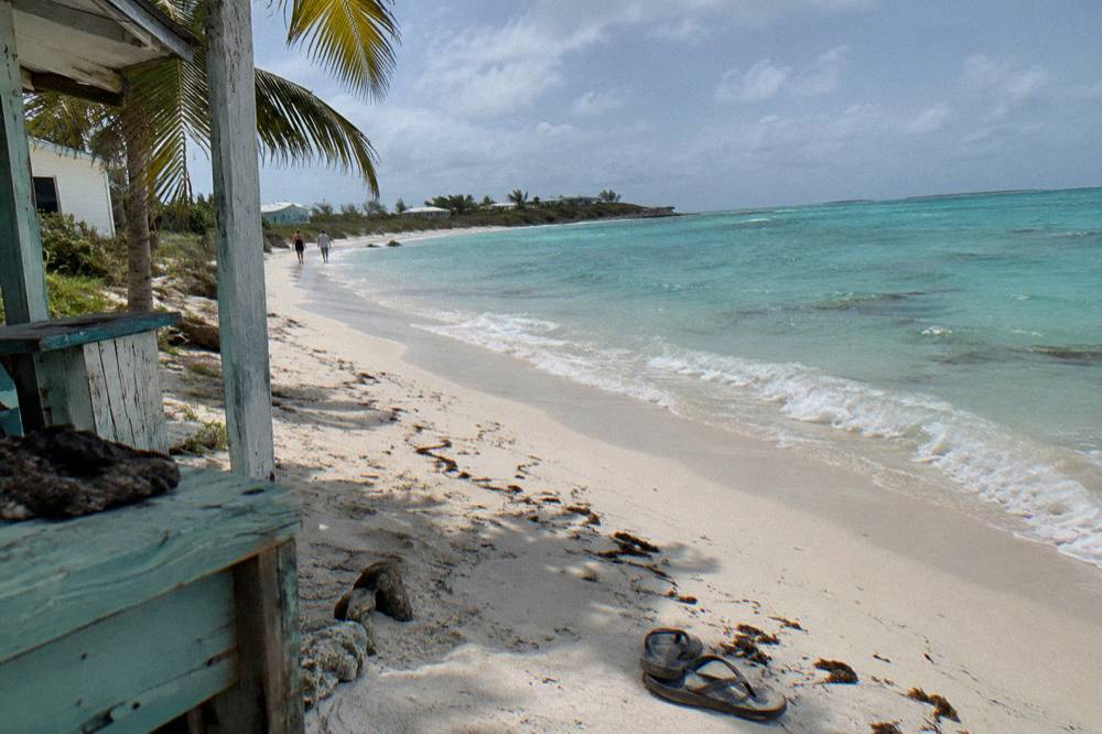 Wide empty white sand beach curving along calm turquoise water
